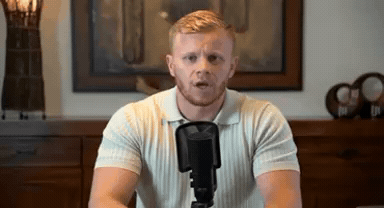 man presenting to camera at desk, laptop, video still
