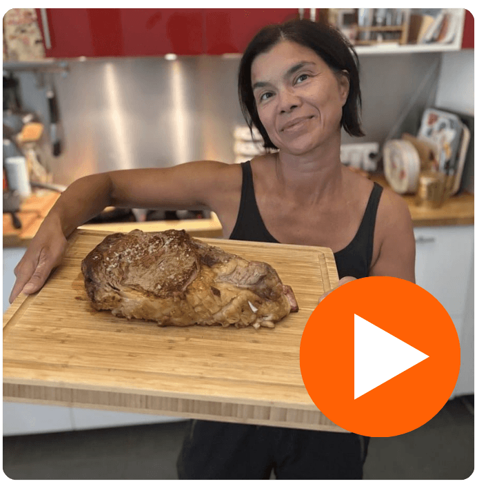Isabelle dans sa cuisine avec une pièce de bœuf grillée