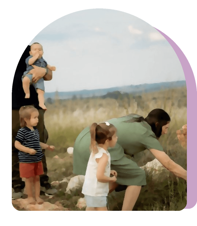 The family exploring rocks and long grass on a hillside