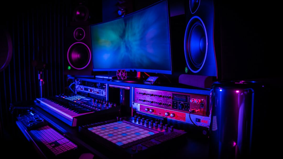 The XMPLA Studio setup with dual monitors, MIDI controllers, and colorful ambient lighting in Wetherill Park