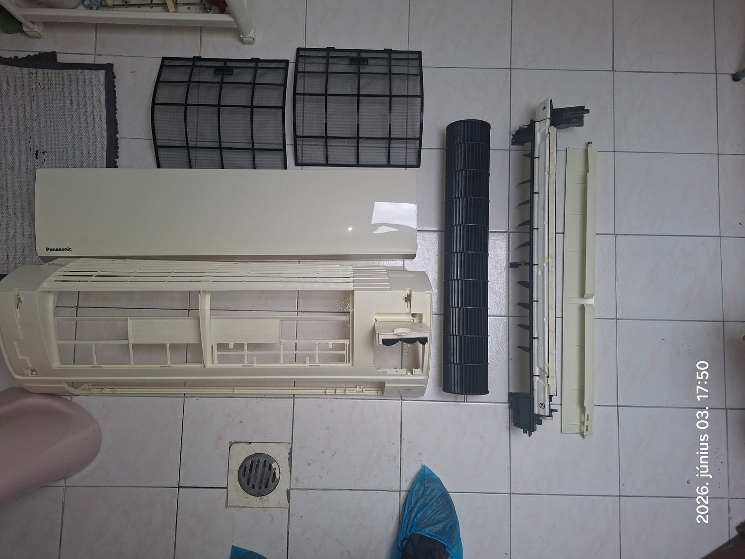 Szétszerelt beltéri egység burkolati elemei és légszűrői a csempén