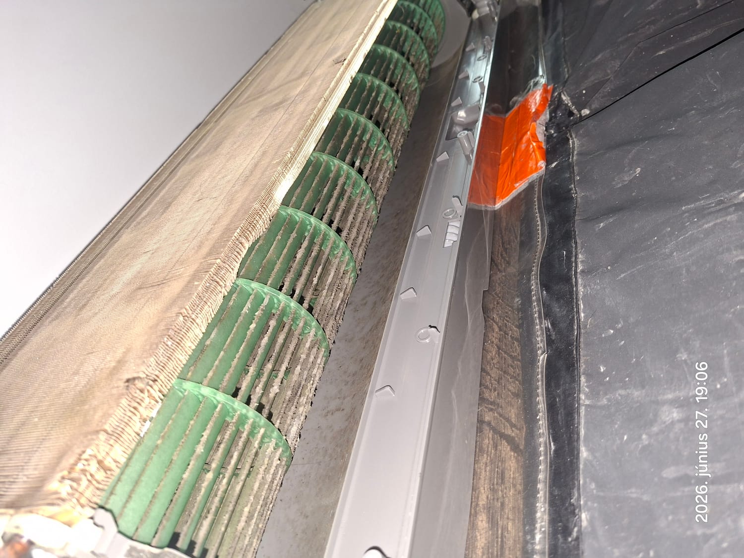 Szennyezett ventilátor a szétnyitott beltéri egységben, alatta gyűjtőfólia