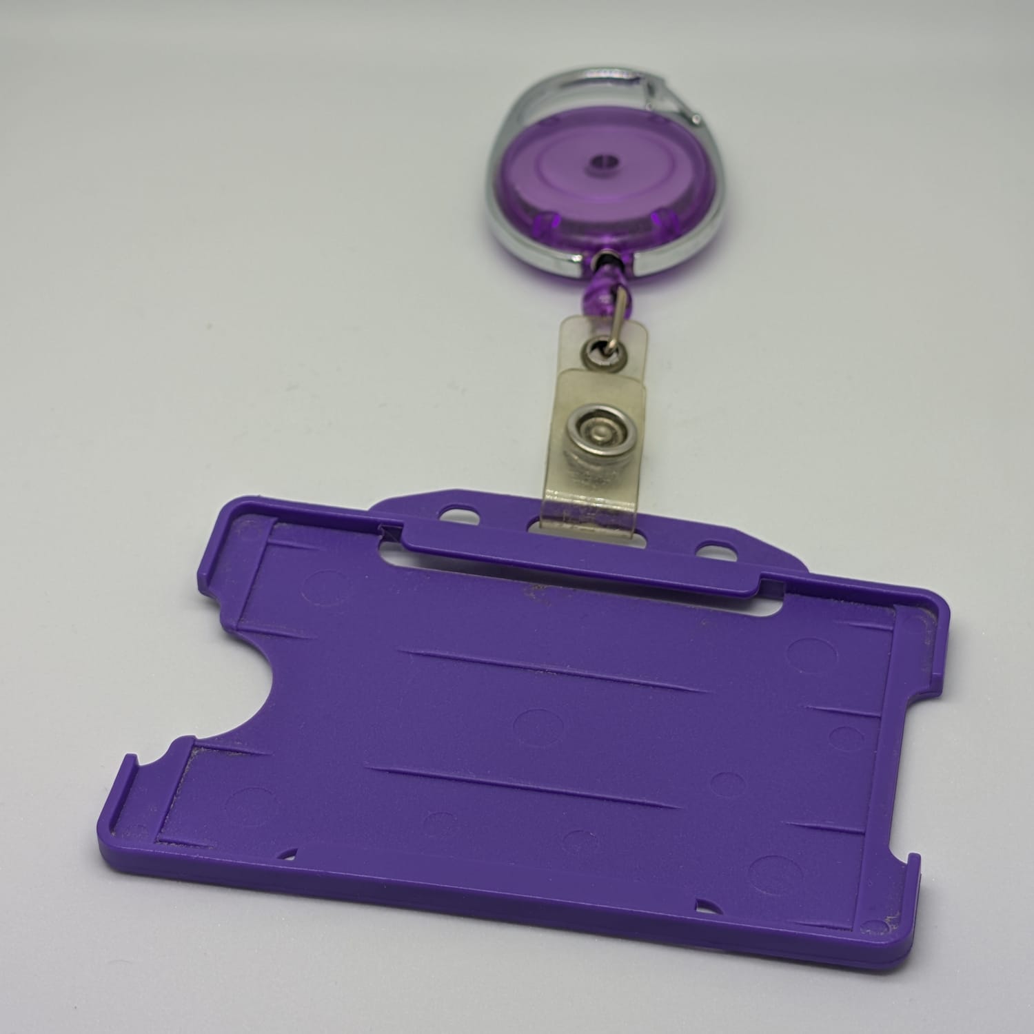 purple lanyard ID badge holder card reel closeup product still life