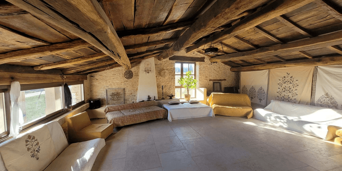 Grande salle avec plafond voûté en bois et poutres