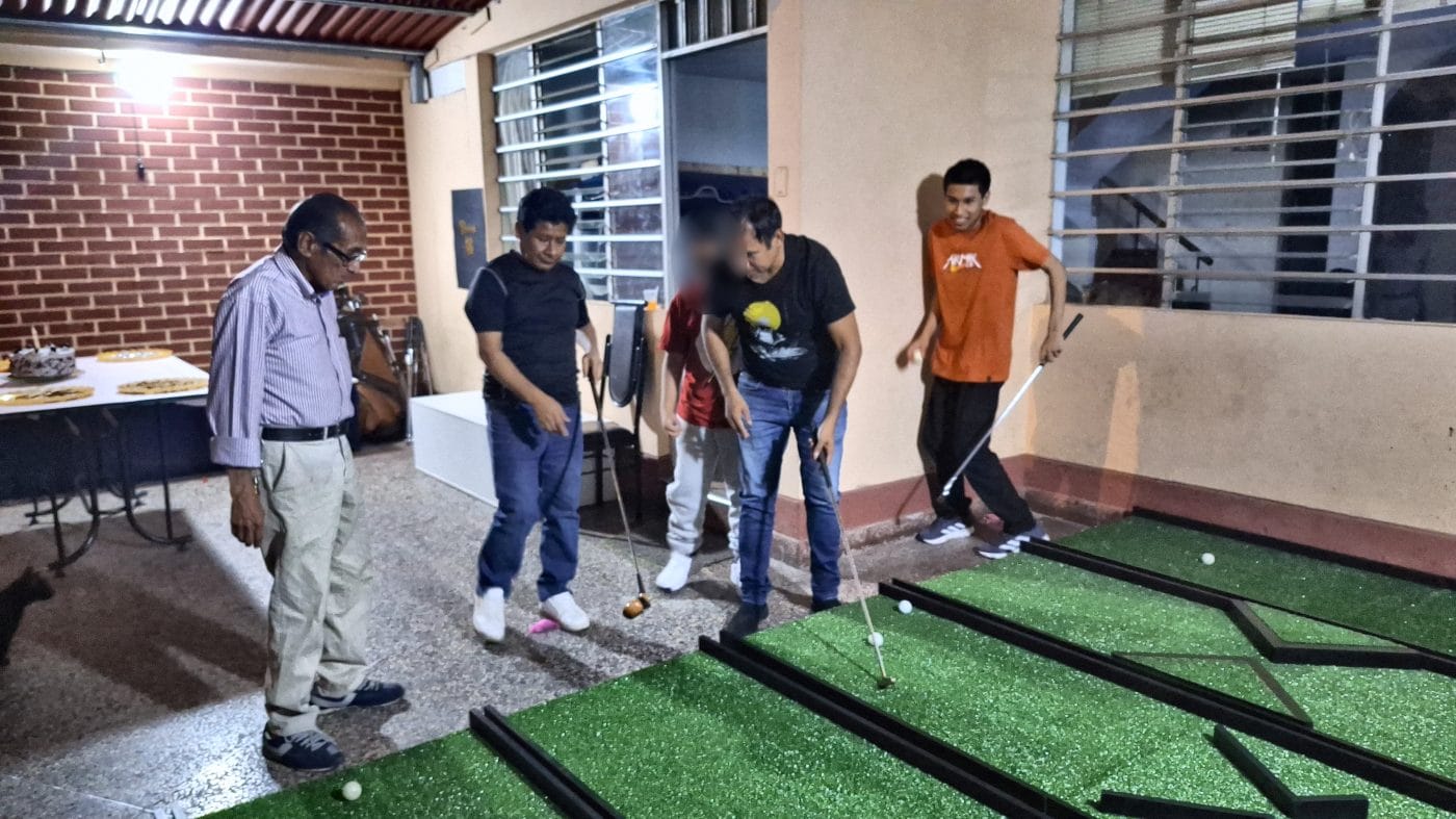 Personas de distintas edades jugando juntas un torneo de minigolf para empresas de 7Lab
