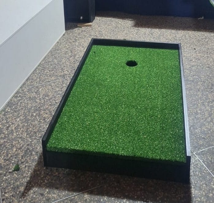 Hoyo de minigolf 7Lab terminado con grass sintético y rieles negros