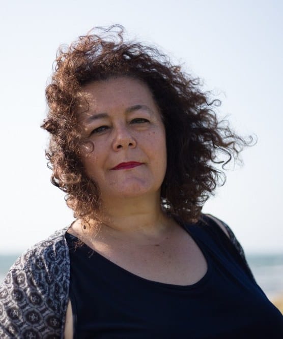 Sabrina Mascanzoni, counselor, in primo piano con lo sguardo verso l'obiettivo e il mare alle spalle