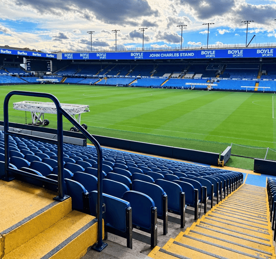 Blue seats, yellow-edged steps and handrails overlooking the pitch at Elland Road.