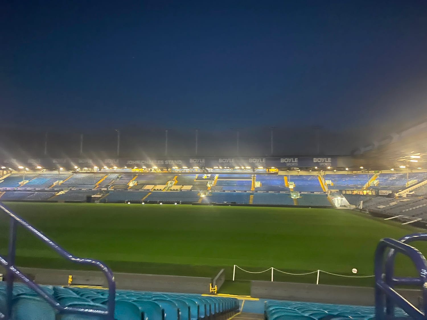 The floodlit John Charles Stand and pitch at Elland Road, viewed from the seating area.