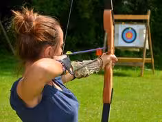 Métaphore représentant une femme au tir à l'arc concentrée pour atteindre la cible en plein centre