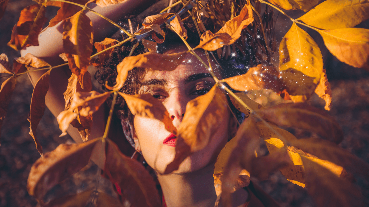 femme parmi les feuilles d’automne, symbole du chemin intérieur pour retrouver confiance en soi et se libérer de ses blocages