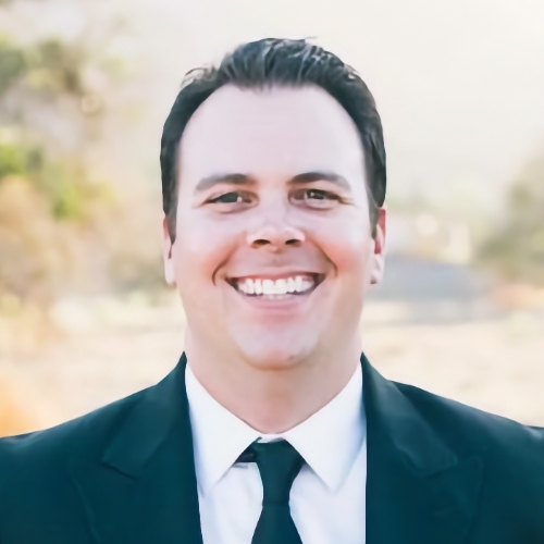 man wearing black suit smiling 