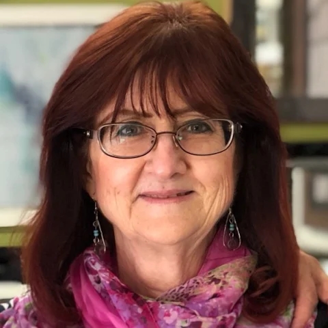 women wearing glasses with red scarf smiling