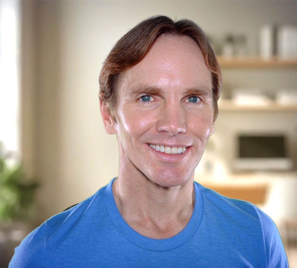a man with light brown hair wearing blue shirt smiling