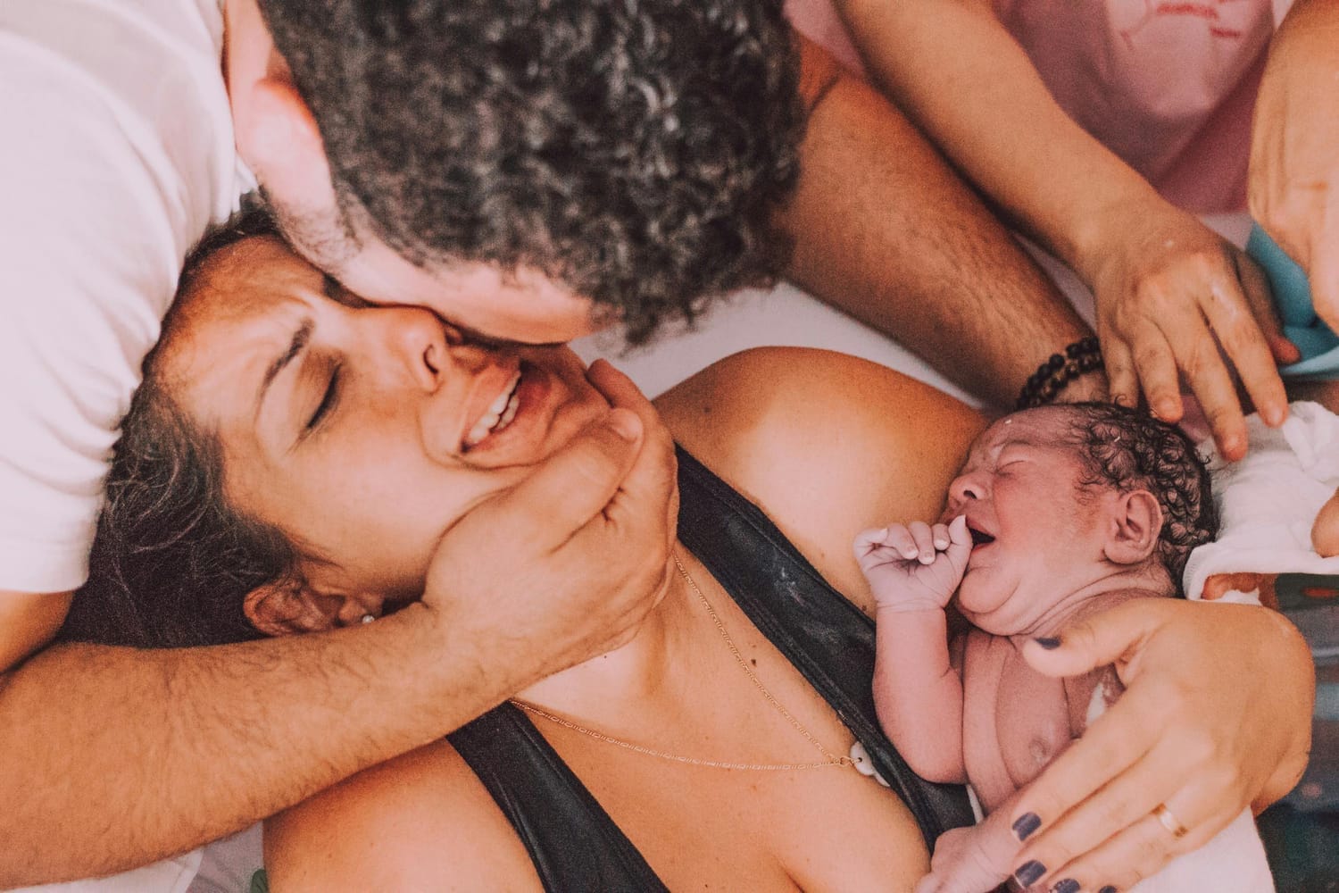 Jeune maman après son accouchement à domicile avec son nouveau-né et son compagnon