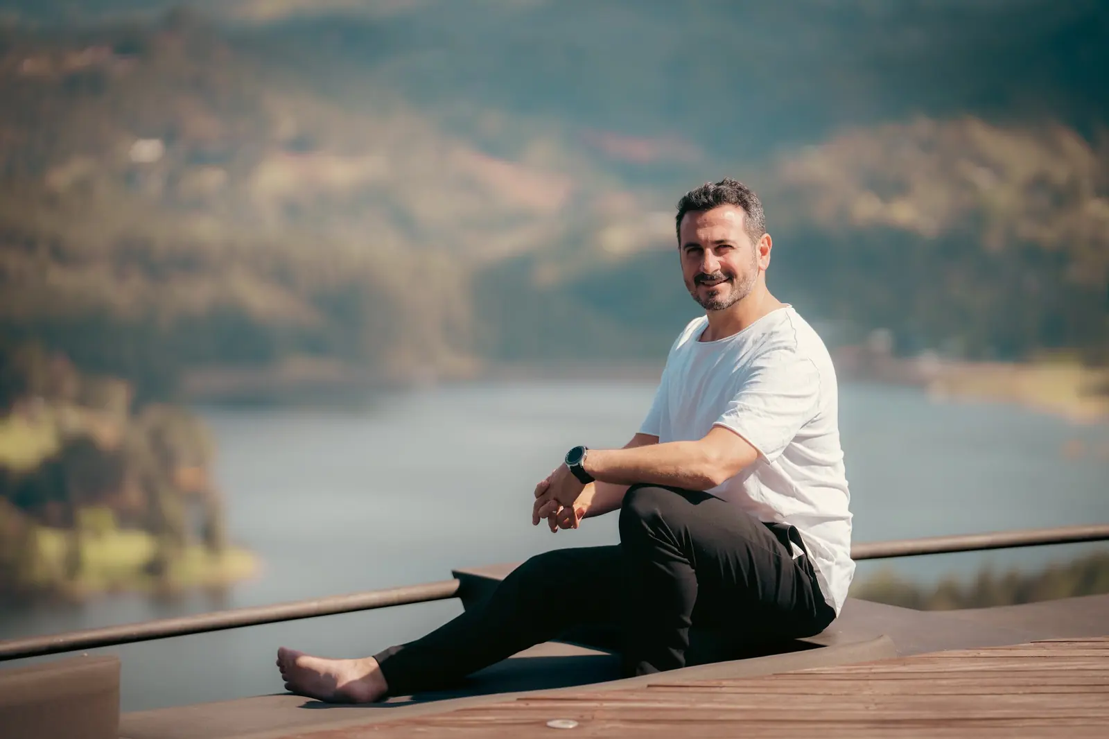 Tony Espigares sentado descalzo frente a un lago entre montañas