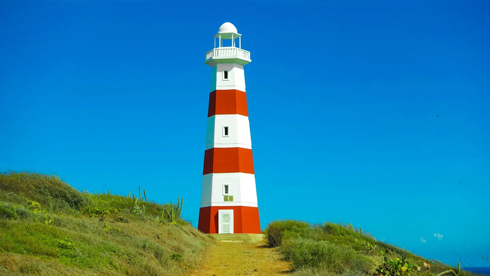El faro rojo y blanco sobre la colina, junto al hotel