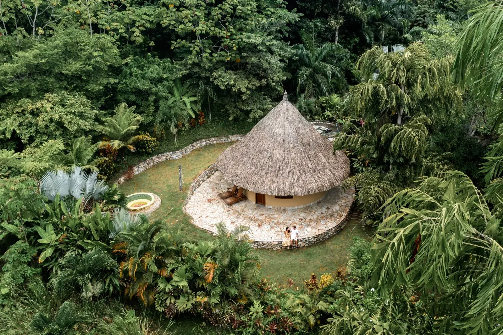 Vista aérea de una cabaña de techo de palma rodeada de selva en One Santuario, Palomino