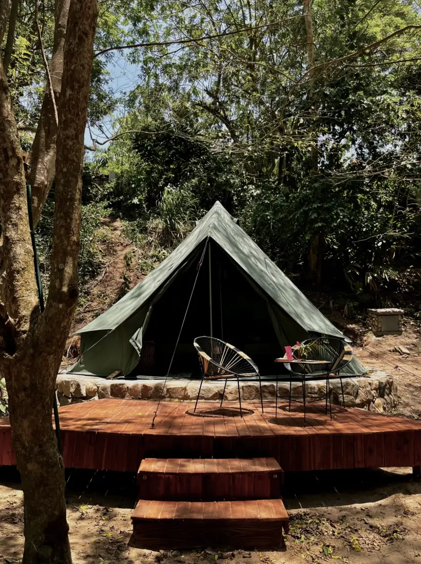 Tienda del eco-glamping sobre su plataforma de madera, entre los árboles