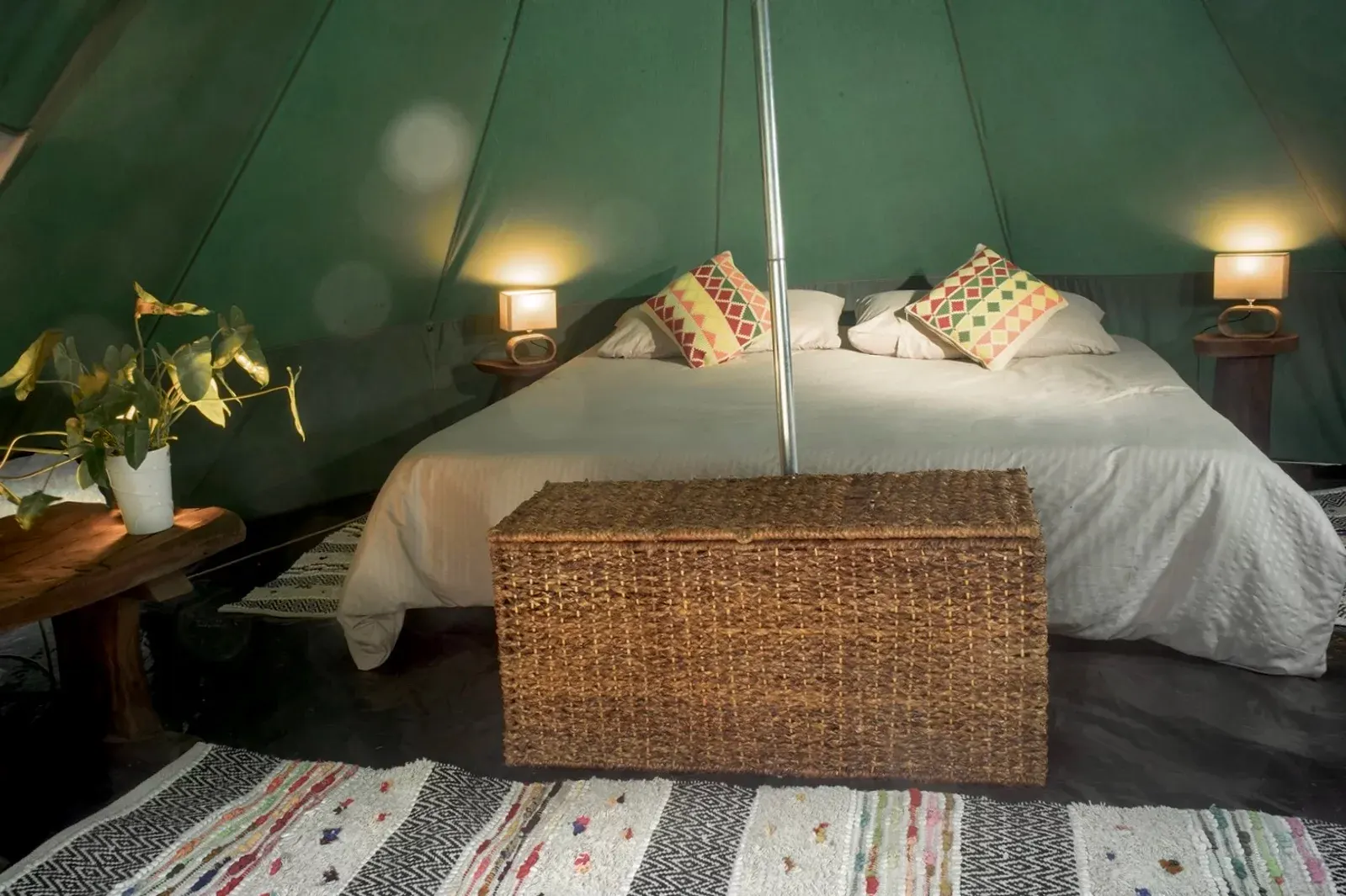 Interior del eco-glamping con cama doble y luz cálida