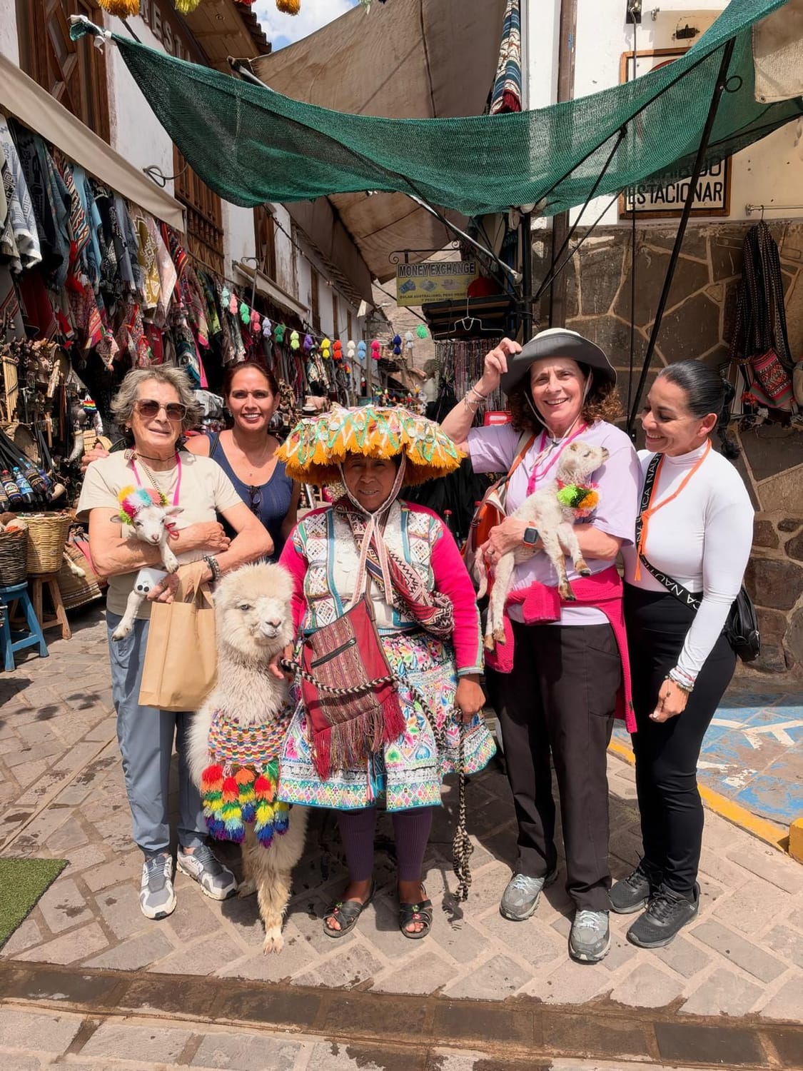Alumnas en el mercado de Pisac con tejedoras y alpacas