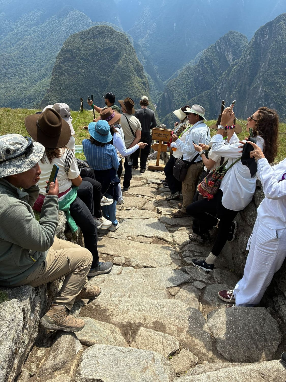 El grupo descansa sentado en un sendero de piedra en Machu Picchu