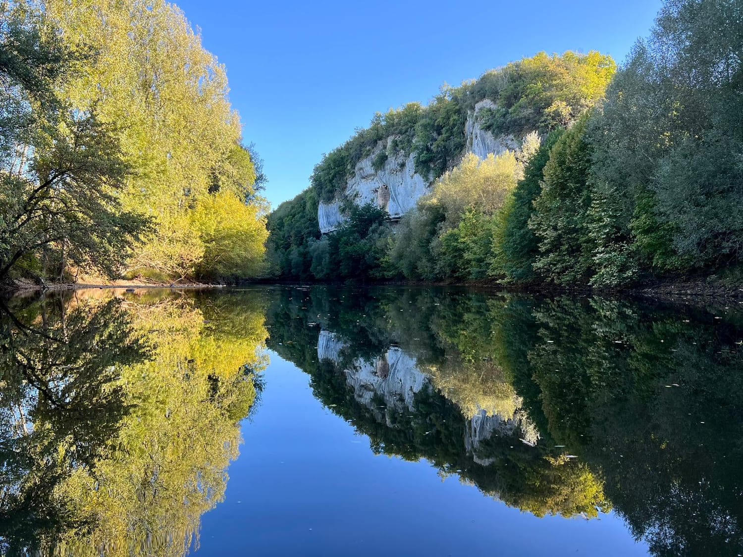 Falaise de Dordogne se reflétant dans la rivière, comme un miroir