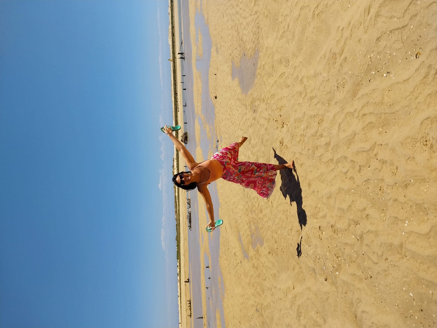 Cindy Phan dansant sur une plage, bras ouverts