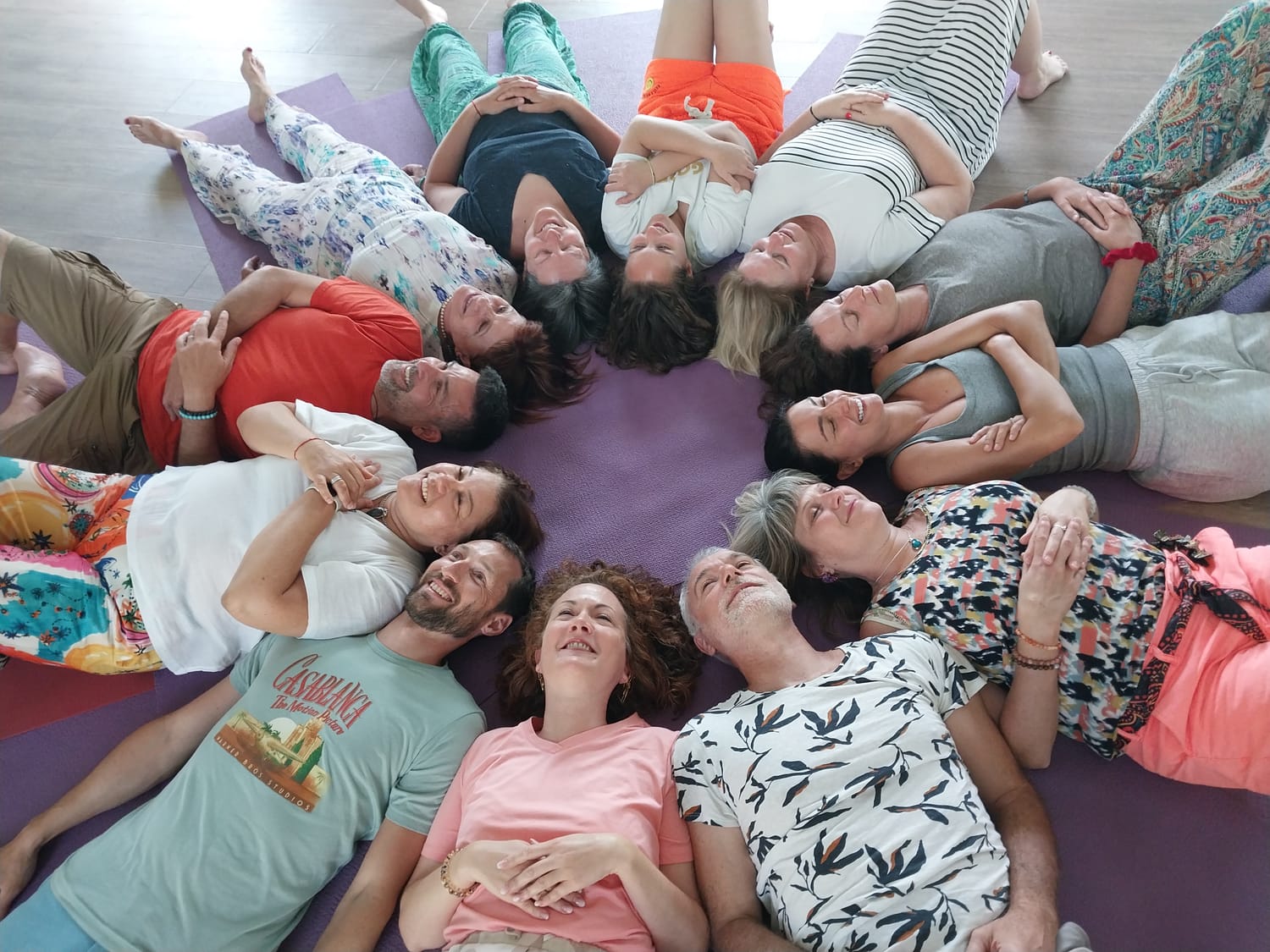 Participants d'un stage allongés en cercle sur des tapis