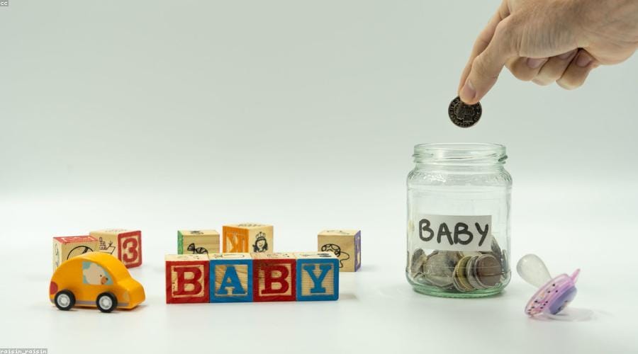 A child watching a plant grow from coins - importance of saving money for kids