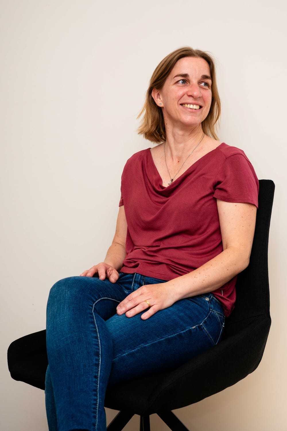 Frédérique assise sur un rocher avec de la végétation derrière elle