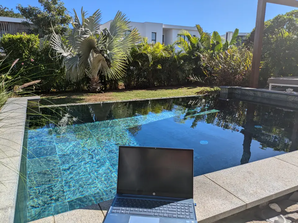 Ordinateur portable ouvert au bord d’une piscine, à l’île Maurice