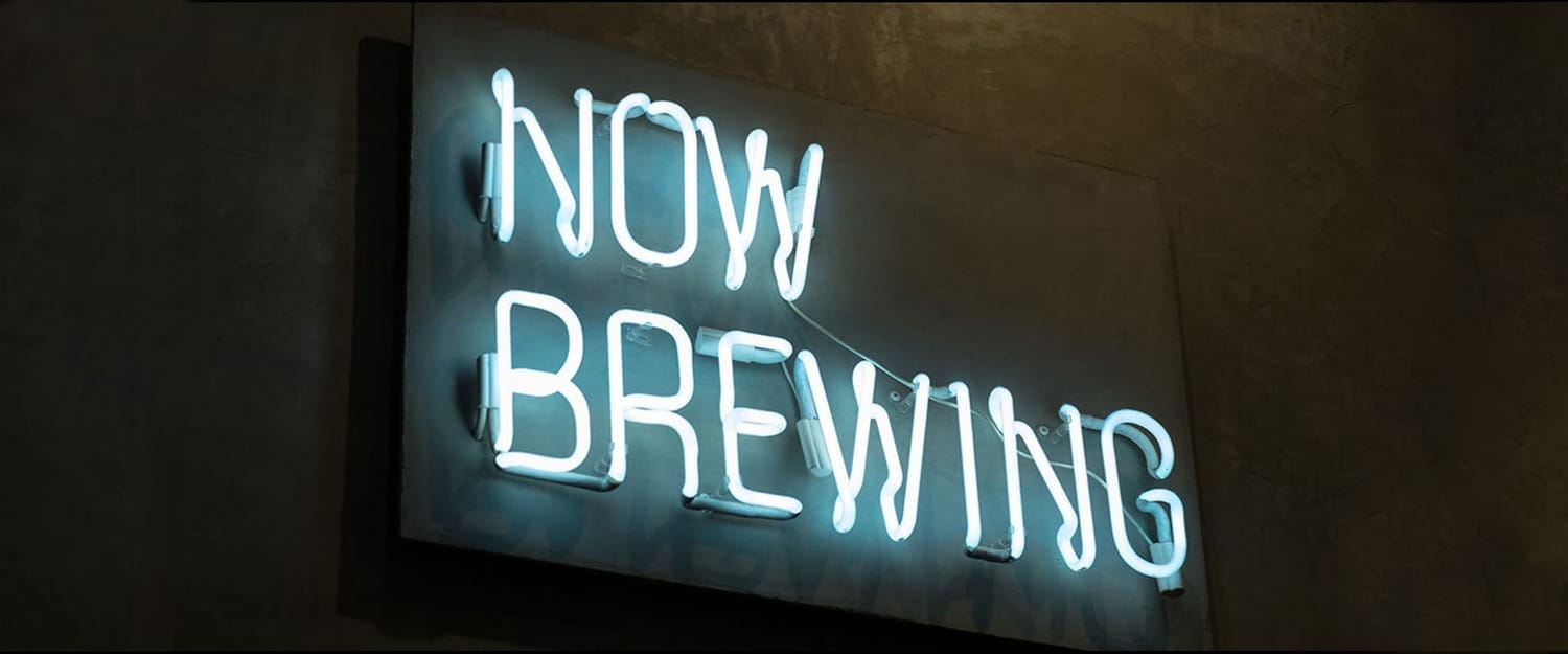 Neon sign reading “Now Brewing” – Cold Brew Coffee Lab marketing sho