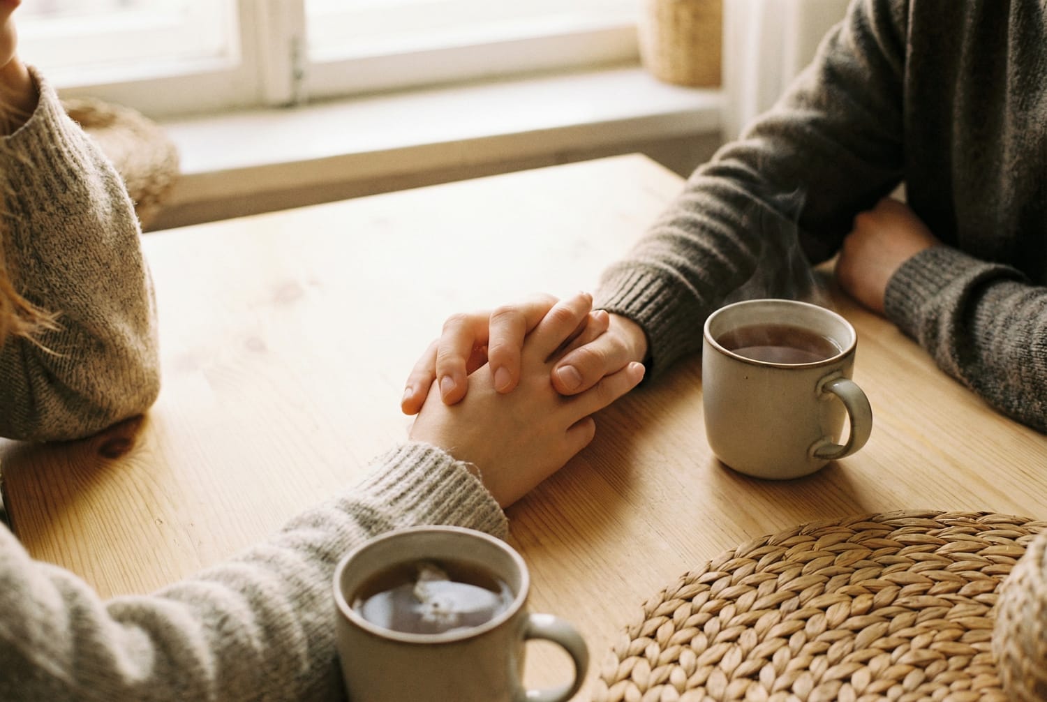 Mains couple entrelacées conversation intime tasses thé