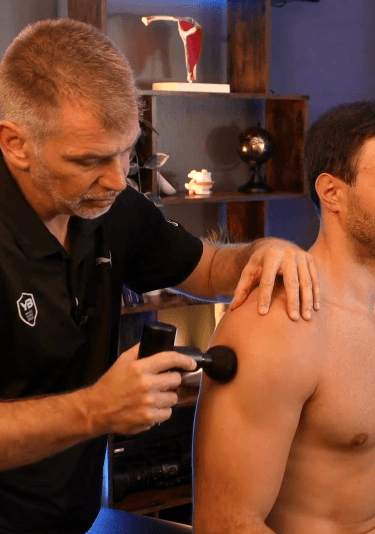 Praticien appliquant le pistolet de massage sur une patiente