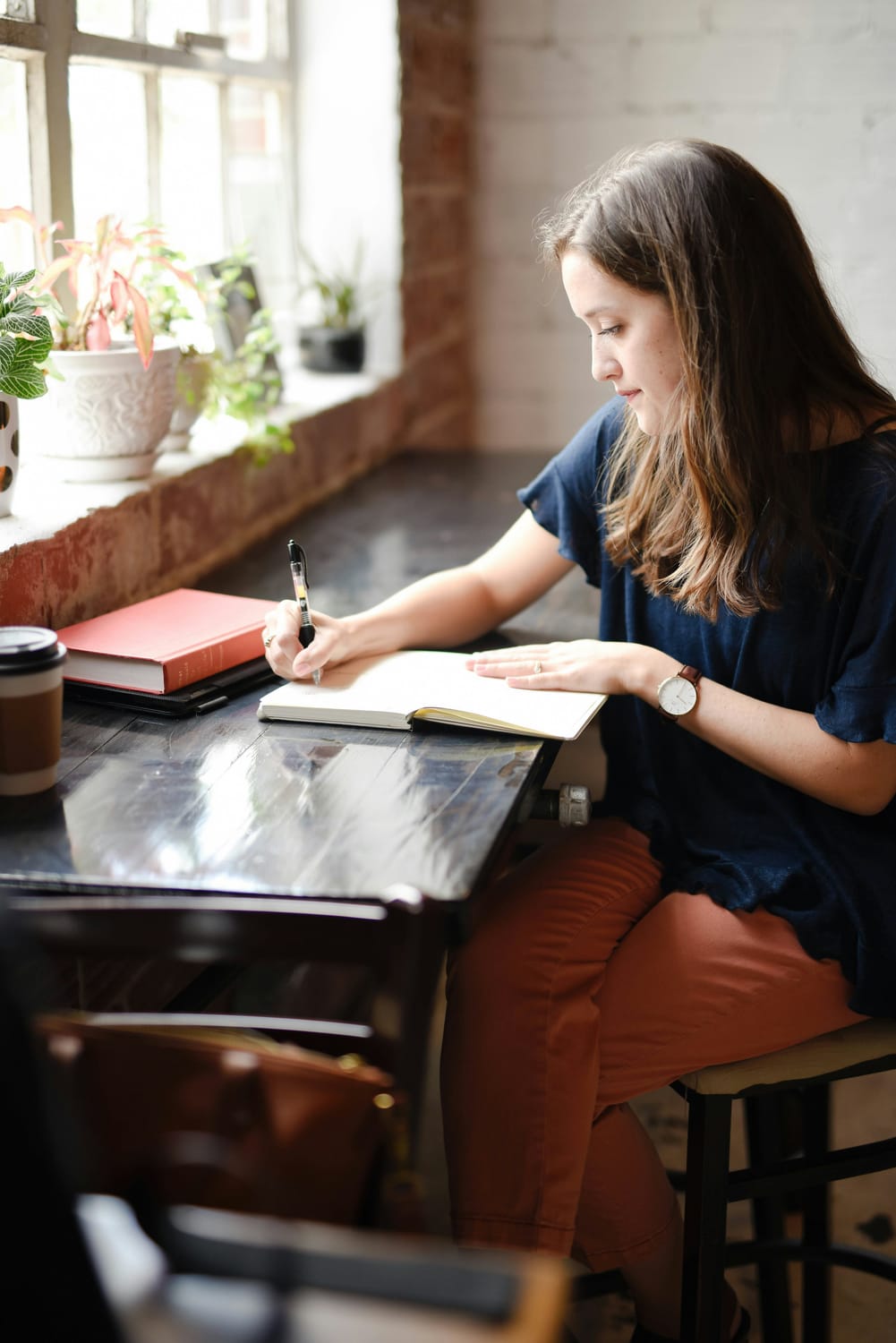 teenager writing notebook sunlit desk