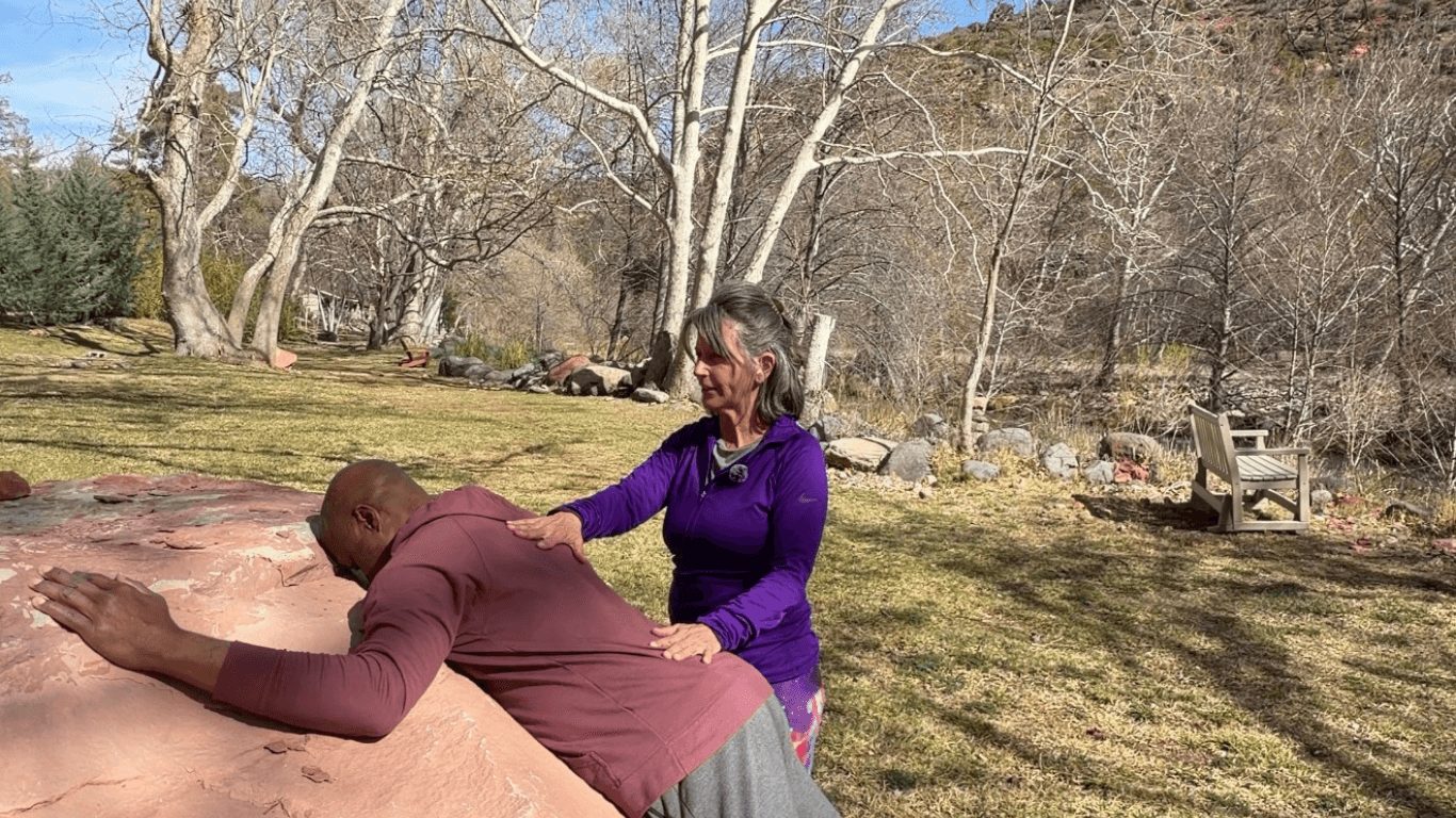 Energy healing and release taking place on Sedona red rock, focused on grounding, presence, and nervous system regulation