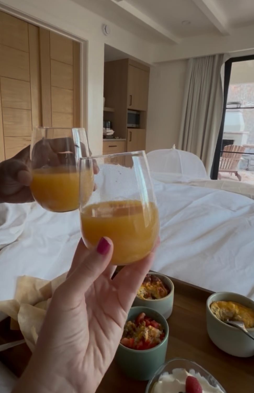 man and women toasting to breakfast in bed, making life an occasion.