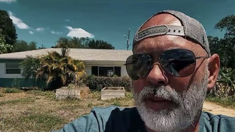David Frizzell in front of a vacant house