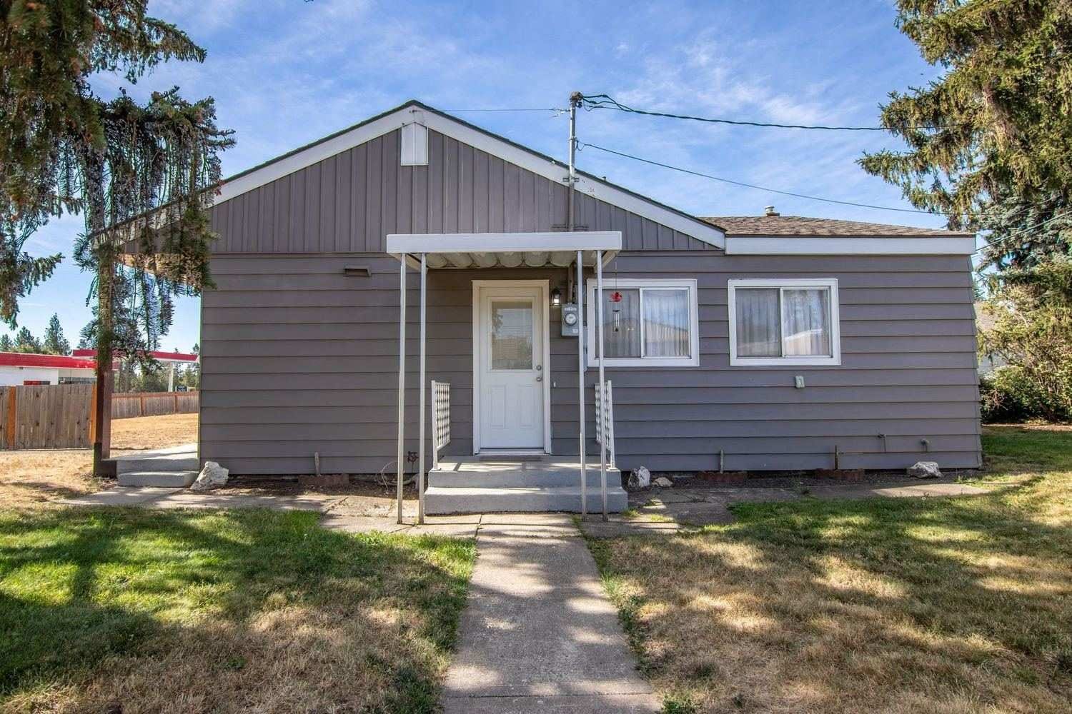 Plain older ranch house with a patchy front lawn