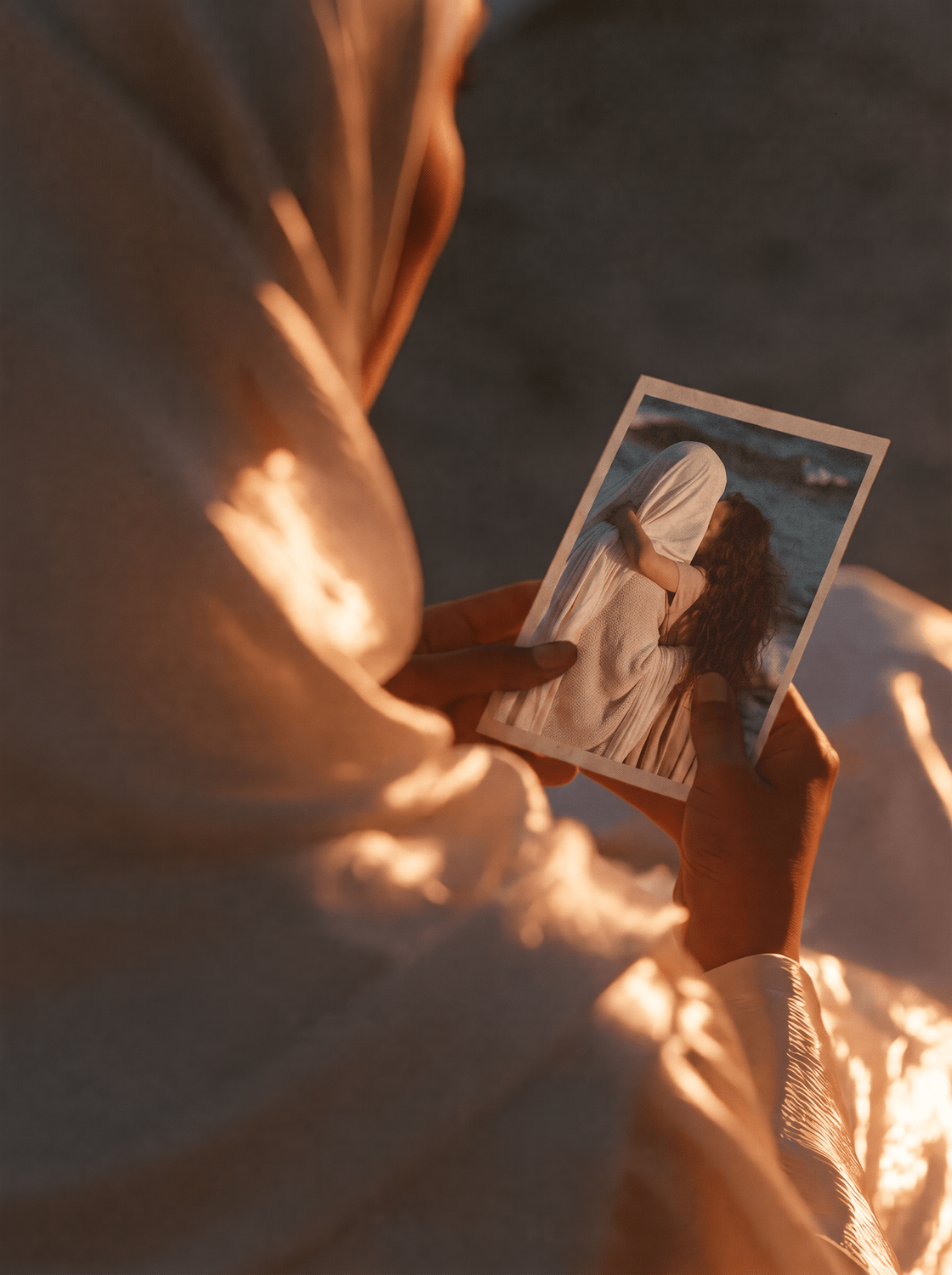 Une femme tient une photographie dans la lumière du soir