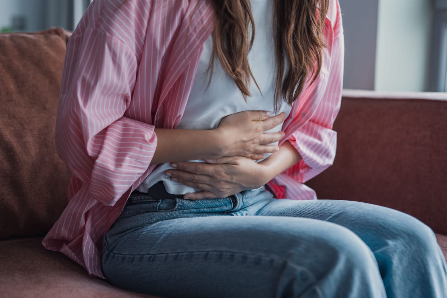 une jeune fille a les mains sur son ventre et se plaint de maux de ventre