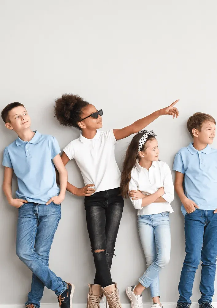 Quatre enfants et adolescents souriants, adossés à un mur, soulagés d'avoir vaincu leurs harcèleurs