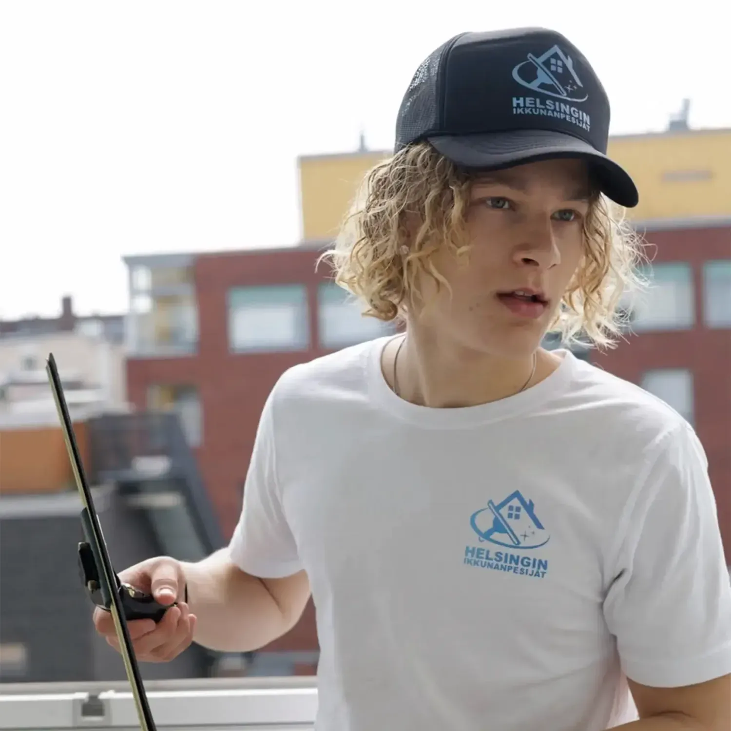 Siivoja taittamassa vaatteita valkoisen sängyn päällä