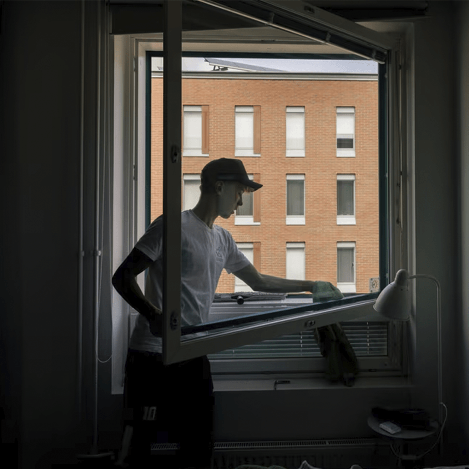 Siivojaan käsi puhdistamassa toimistossa työpöytää johon on läikkynyt kahvia