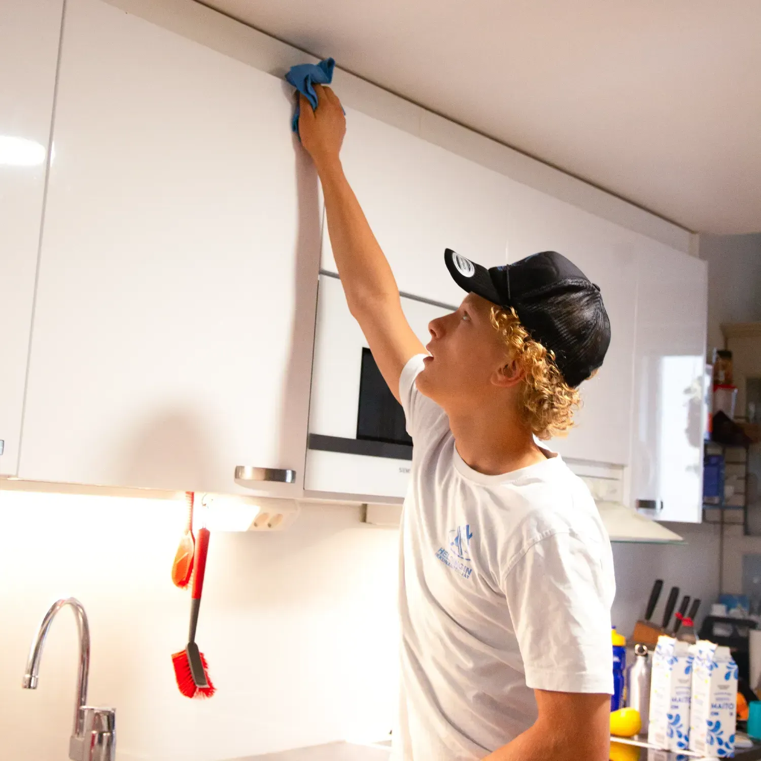 Ihminen kastelemassa vihreää kasvia siistissä kodissa