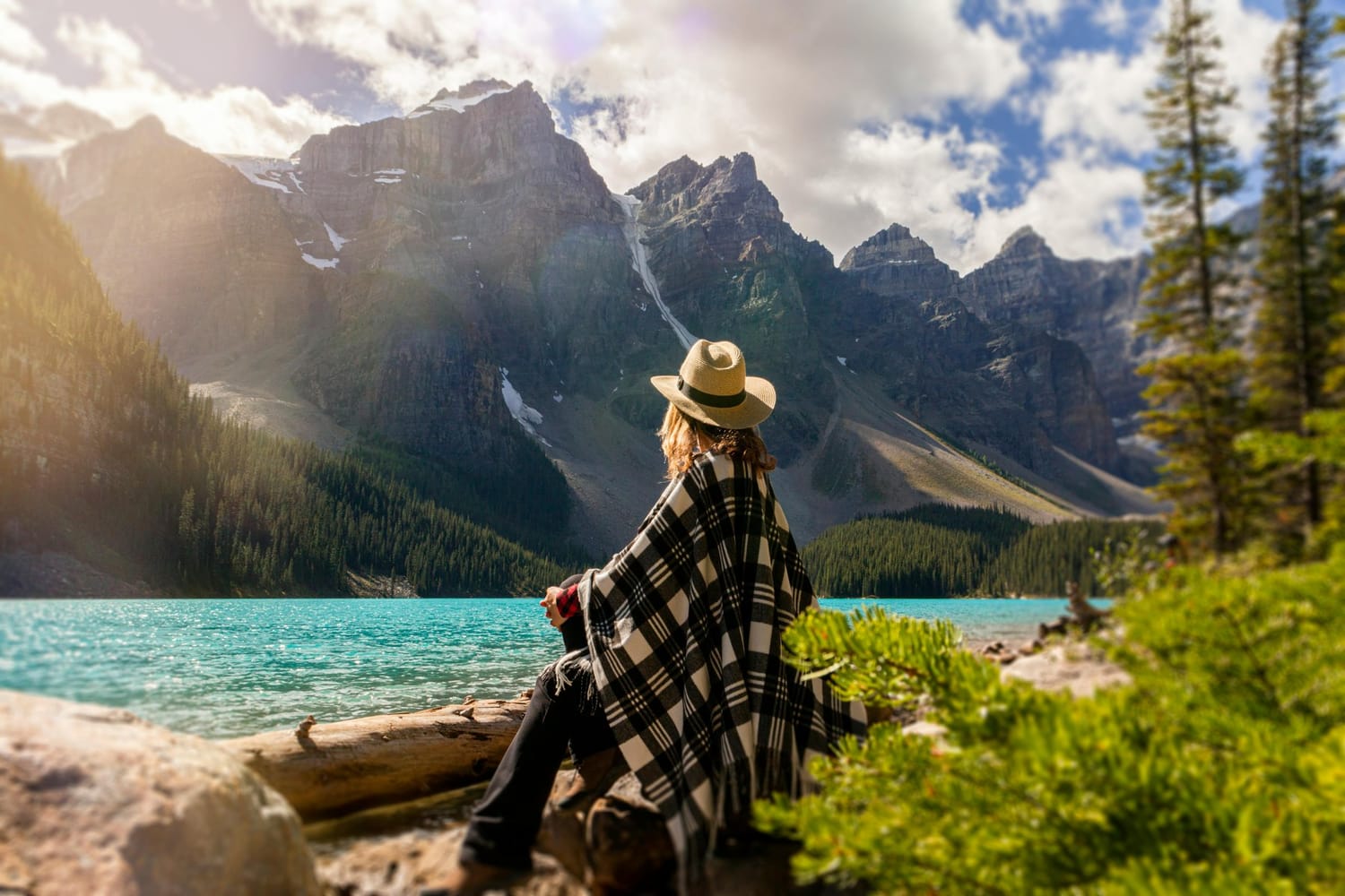 A lake, forest, and mountains in morning light.