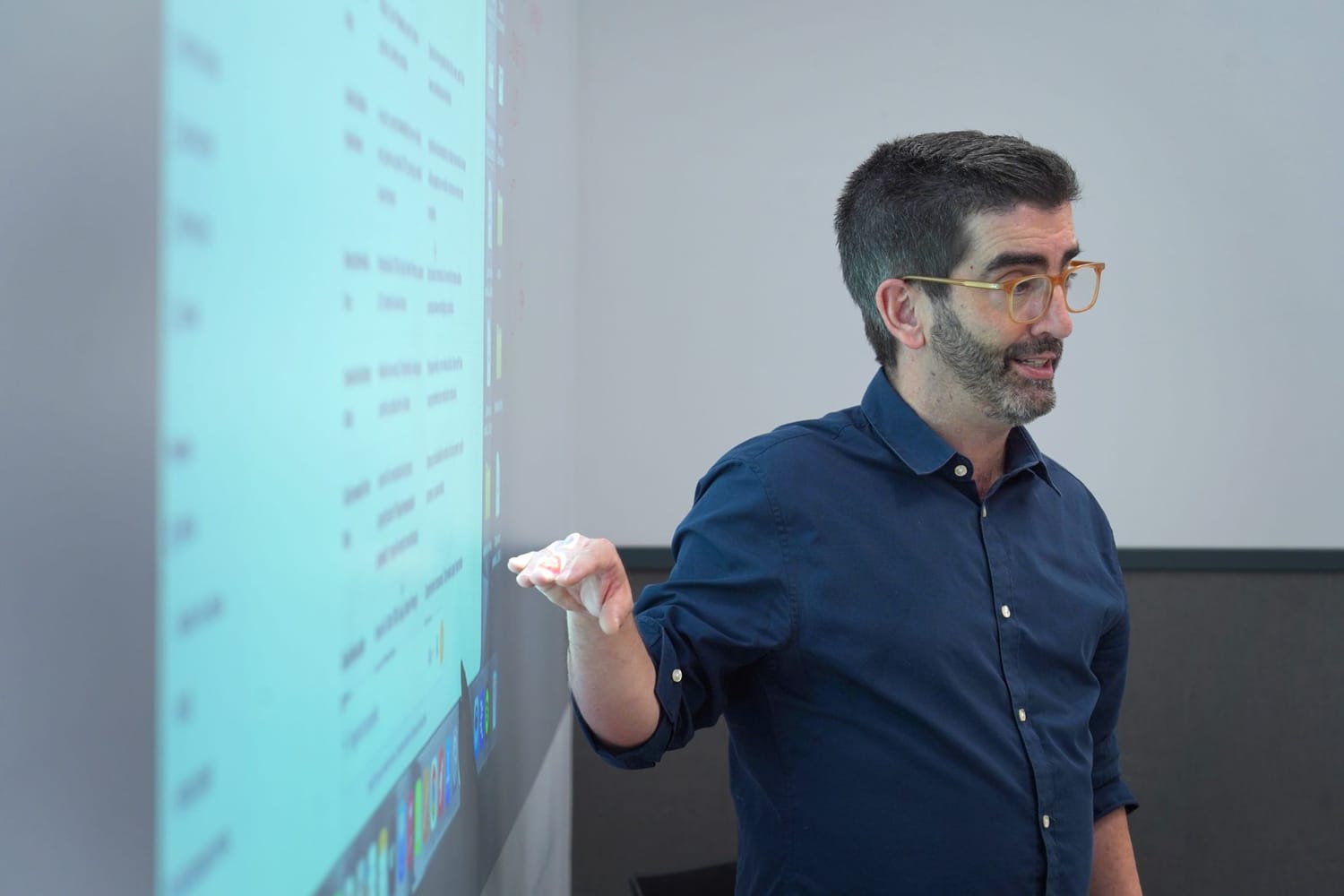 Nacho Caballero impartiendo una sesión de formación junto a una pantalla de proyección