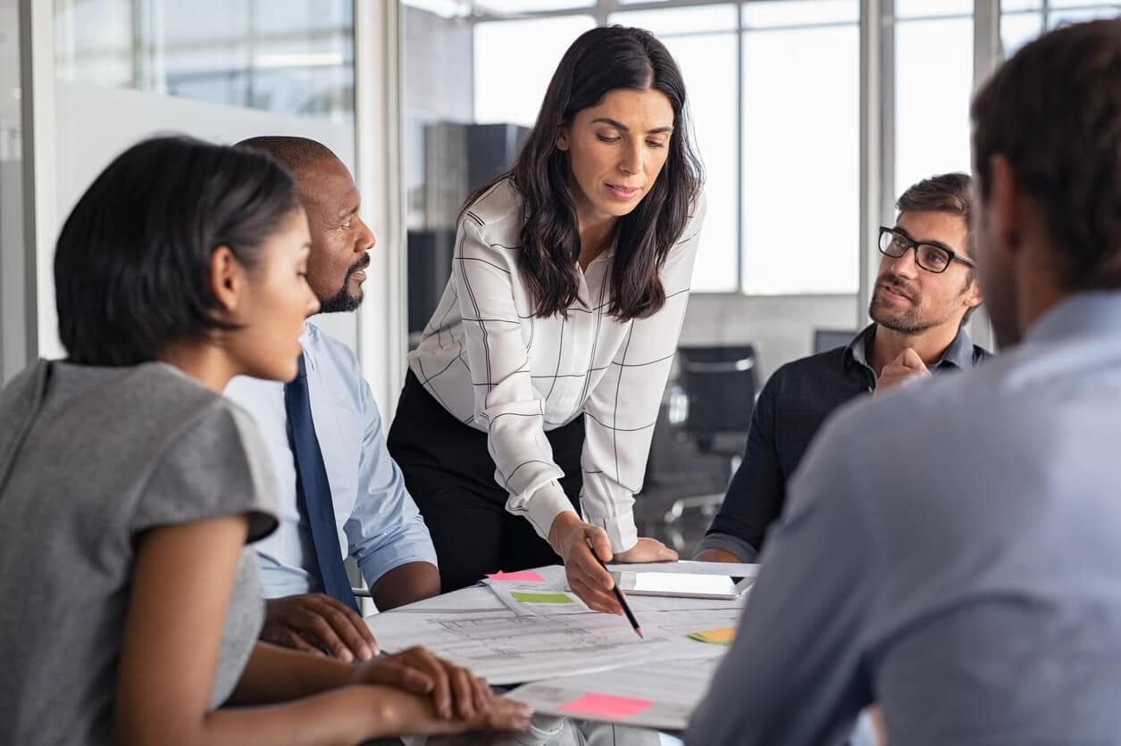 Mujer líder guiando a su equipo en una reunión profesional
