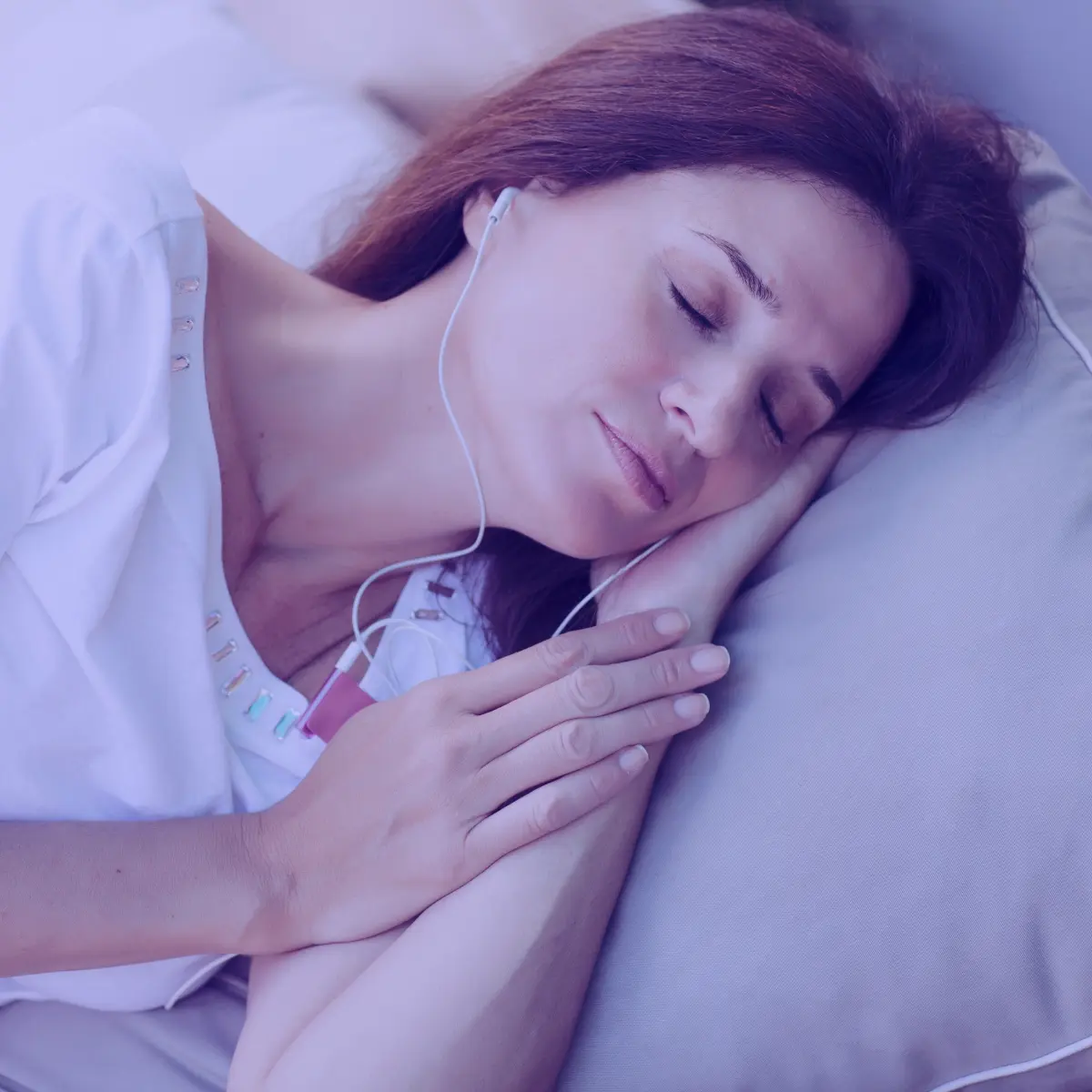 Woman with earphones listening to sleep hypnosis program with Theta brainwave entrainment